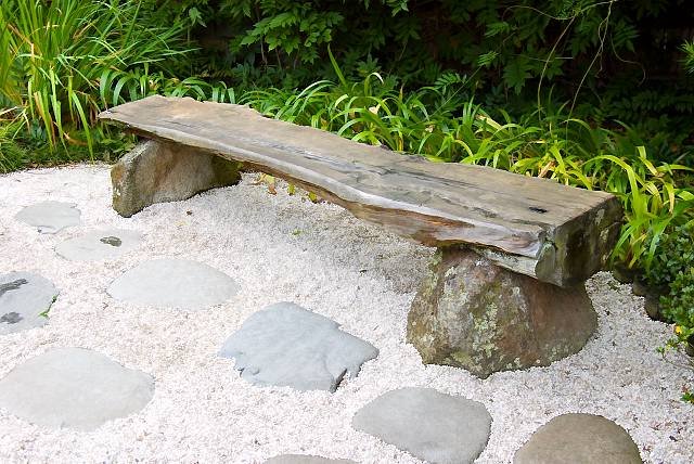 Оригинальная скамейка построенная из бревна и камней